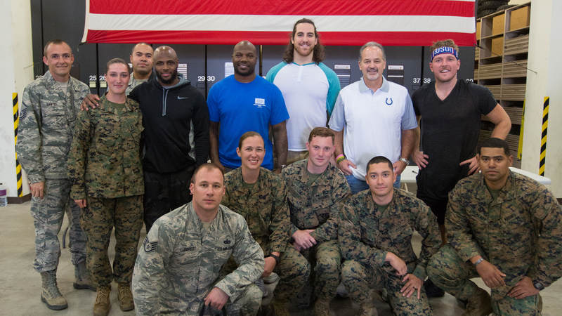 Coach Pagano along with players Pat McAfee (right), Anthony Castonzo (third right), D'Qwell Jackson (fourth rights) and Mike Adams (fourth left) pose for a photo with the Marine Corps K-9 Okinawa team during a USO tour stop at Kadena AFB in Okinawa, Japan, on Feb. 19.