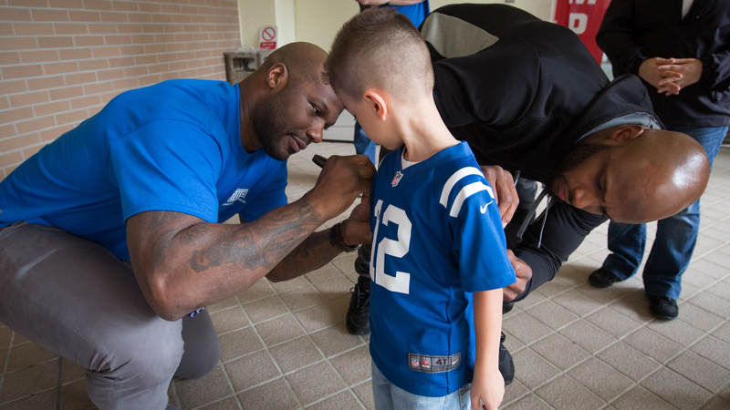 Jackson (left) and Adams (right) autograph the jersey of a young fan during a USO tour stop at MCAS Futenma in Okinawa, Japan, on Feb. 19.