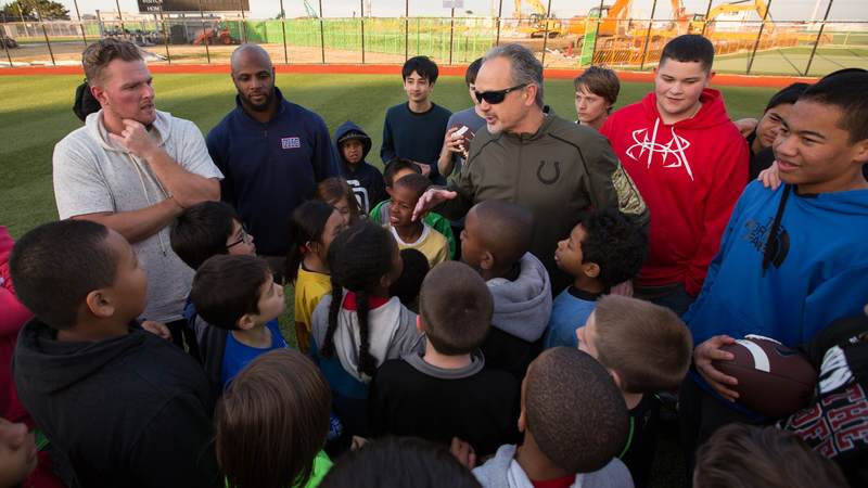 Coach Pagano (center), McAfee (left) and Adams (second left) encourage the children of service members after running them through football drills at a USO tour stop at a kids' after-school athletics program at Fleet Activities Yokosuka naval base on Feb. 17.