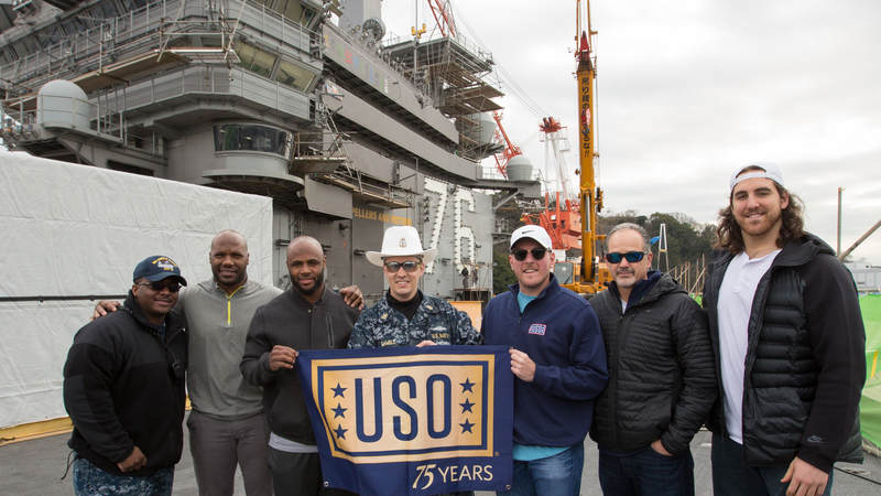 Jackson (second left), Adams (third left), McAfee (third right), Anthony Castonzo (right) and Coach Pagano (second right) pose for a photo with service members on the flight deck of the USS Ronald Reagan at Fleet Activities Yokosuka naval base on Feb. 18.